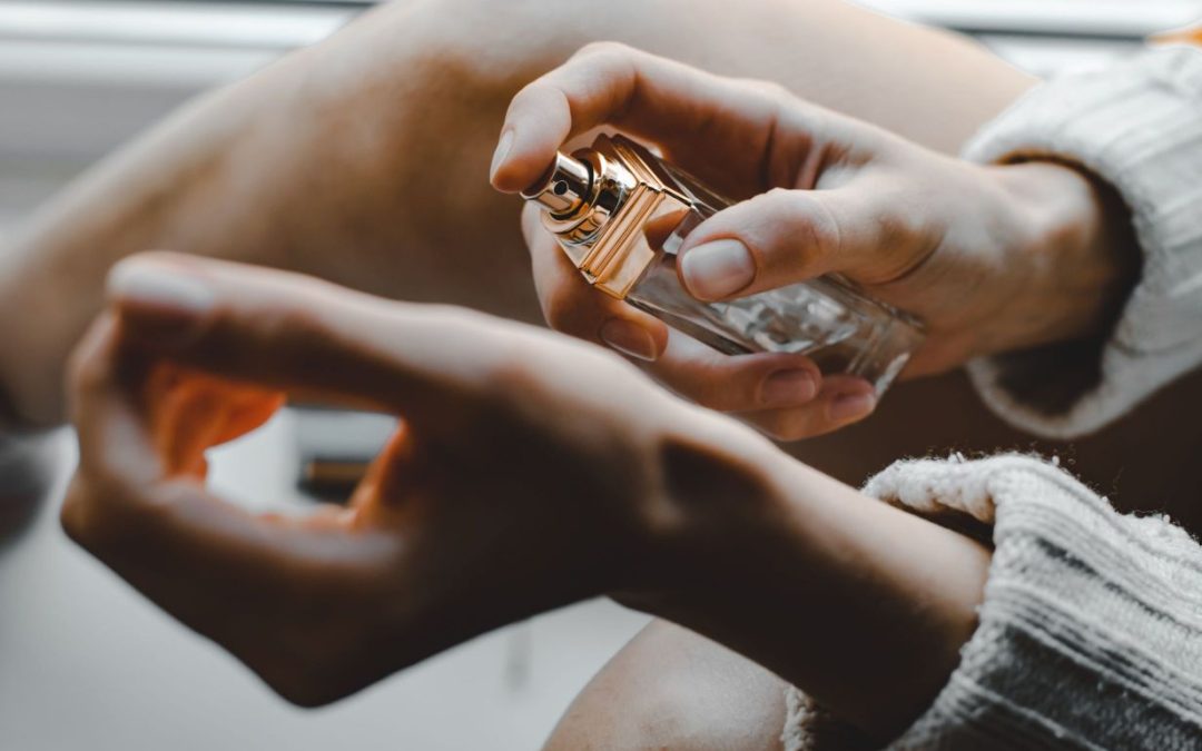 Woman spraying perfume on her wist