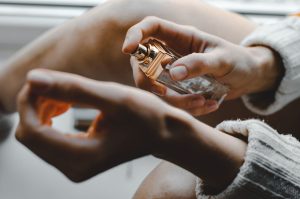 Woman spraying perfume on her wist