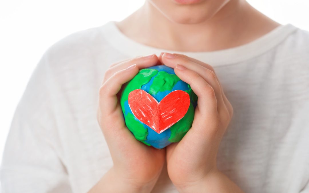 boy holding a little earth with a heart on it