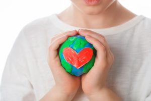 boy holding a little earth with a heart on it