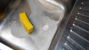 évier plein de mousse avec une éponge